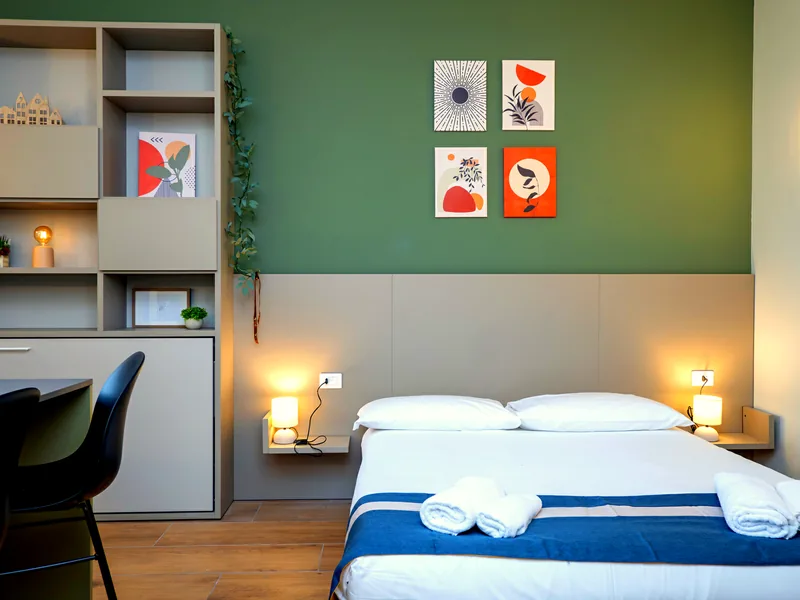 Letto matrimoniale e parete salvia
