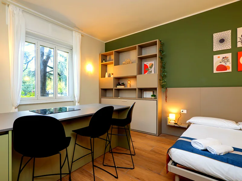 Cucina, tavolo e letto in un unico ambiente